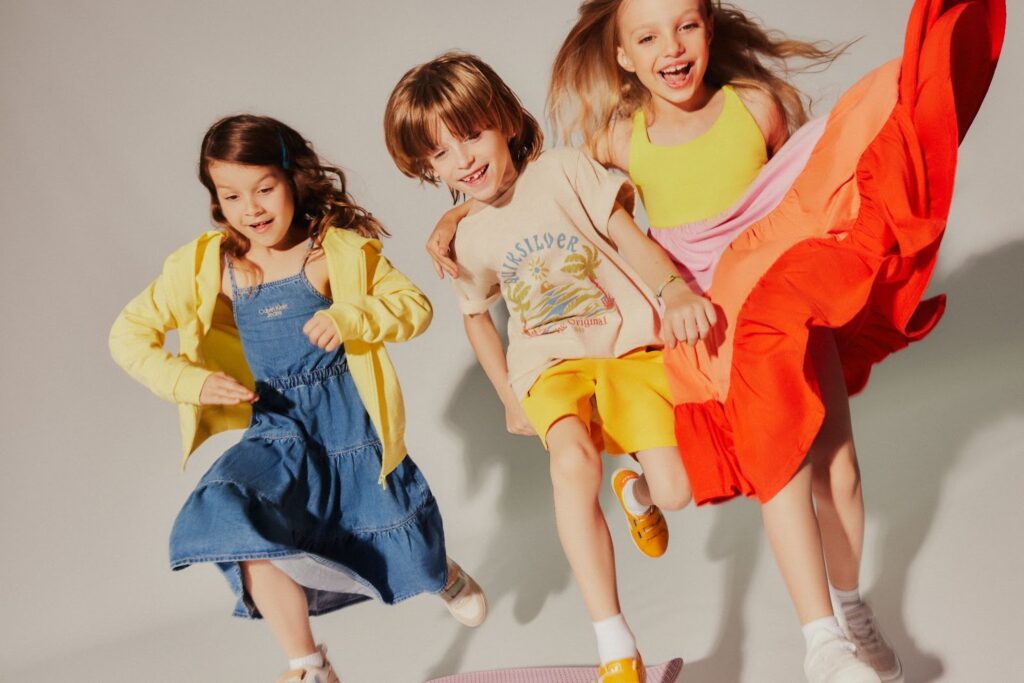 Două fete și un băiat în haine colorate de vară