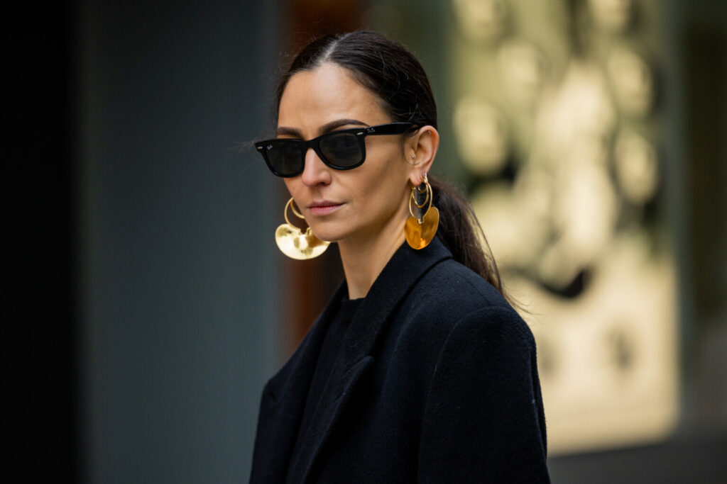 PARIS, FRANCE - JANUARY 27: Ilenia Toma wears black oversized double breasted coat, golden earrings, sunglasses outside Patou at La Samaritaine on January 27, 2023 in Paris, France. (Photo by Christian Vierig/Getty Images)