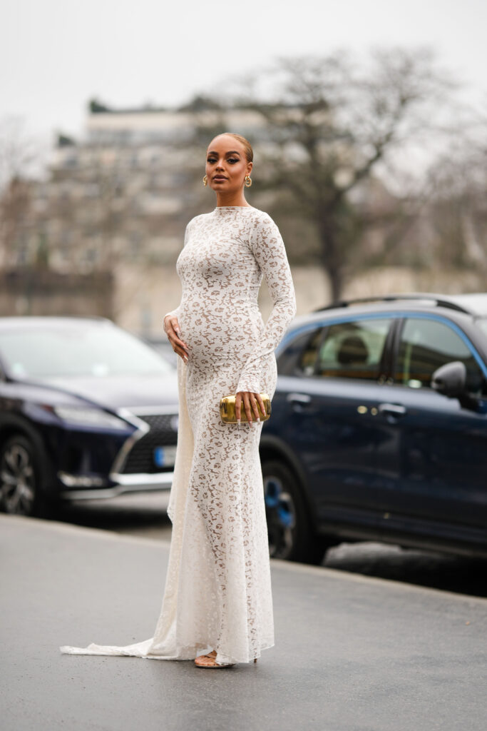 Alicia Aylies poartă cercei aurii, o rochie cu mâneci lungi / rochie tubulară lungă cu model cu imprimeu floral din dantelă albă, sandale cu toc cu barete strălucitoare bej , în afara Stephane Rolland, în timpul Săptămânii Modei de la Paris - Haute Couture primăvară-vară, pe 24 ianuarie 2023, la Paris, Franța.