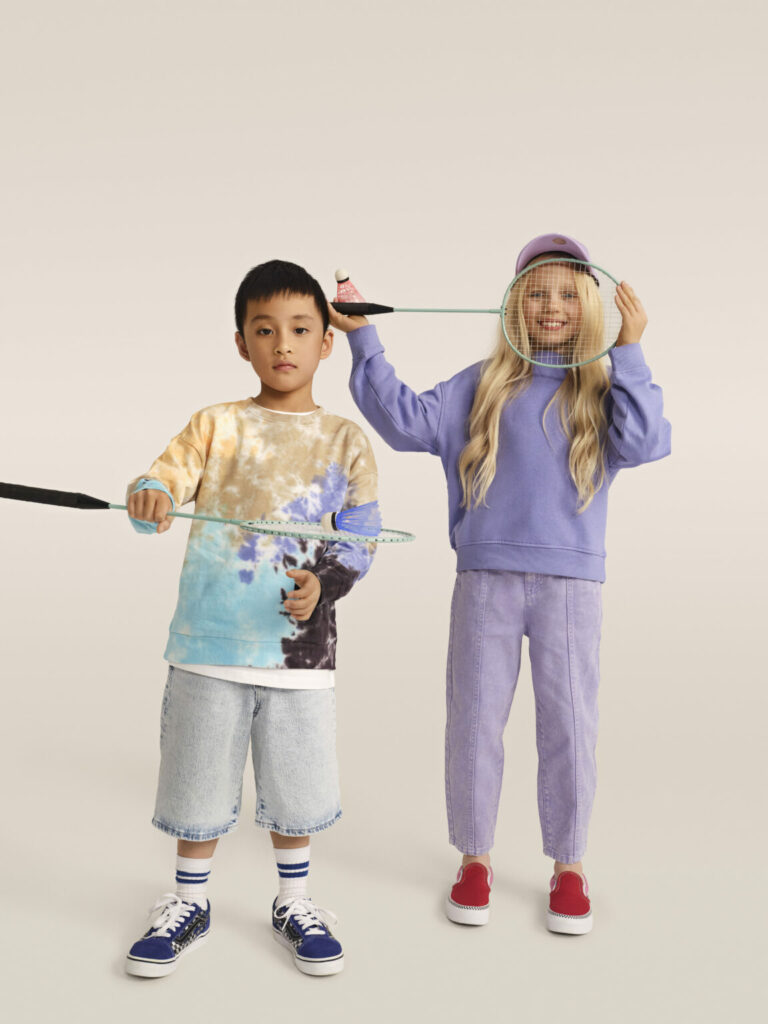 Băiat și fată pozând cu rachete de badminton