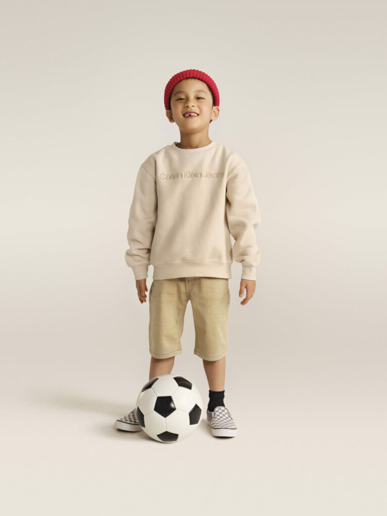 Băiat în adidași Vans și un hanorac bej Calvin Klein Jeans