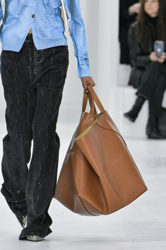 Un model pășește pe podium cu o geantă shopper XXL maro