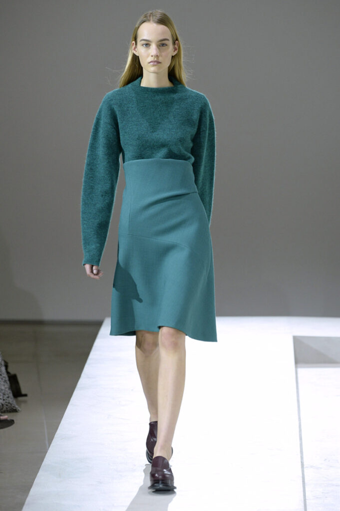 un model în show-ul Jil Sander într-o rochie de culoare petrol