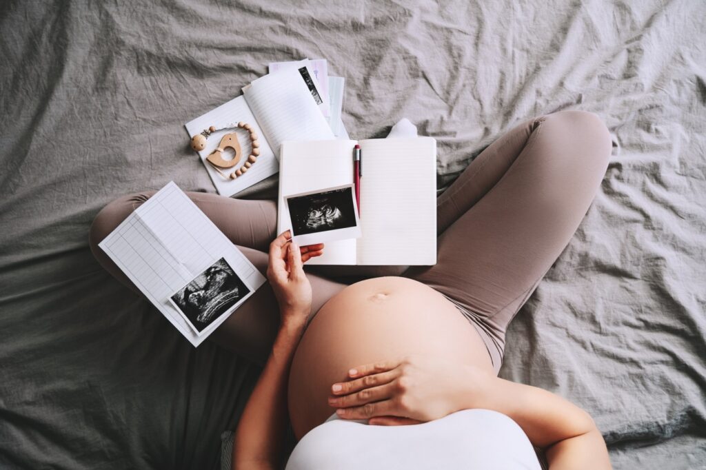 o femeie însărcinată examinează imagini cu ultrasunete
