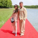 David și Victoria Beckham, pe covorul roșu, purtând ținute din in.