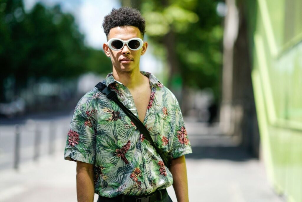 Un bărbat care poartă o cămașă hawaiană și ochelari de soare